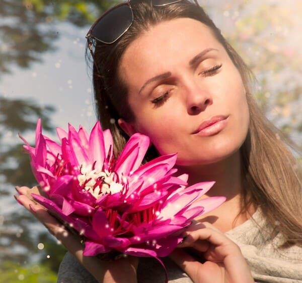 Visage d'une femme aux yeux fermés en gros plan à côté d'une fleur