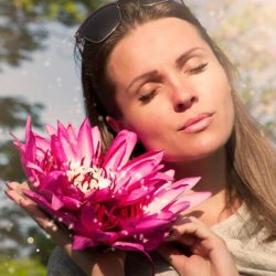 Visage d'une femme aux yeux fermés en gros plan à côté d'une fleur